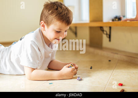 Due ragazzi giocare con lego a casa con luce da sfondo finestra Foto Stock