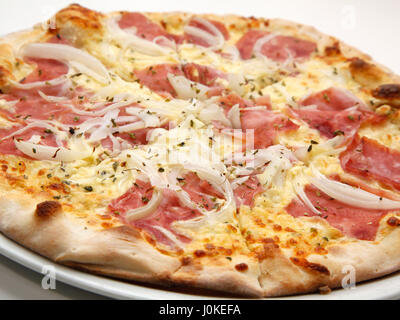 Una deliziosa pizza fresca con prosciutto e le cipolle su sfondo bianco. Il fuoco selettivo DOF poco profondo Foto Stock