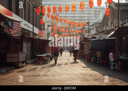 Kuala Lumpur, Malesia - 17 Marzo 2016: la gente camminare attraverso Petaling Street mentre altri mangiare presso le bancarelle in Chinatown durante il mornin Foto Stock