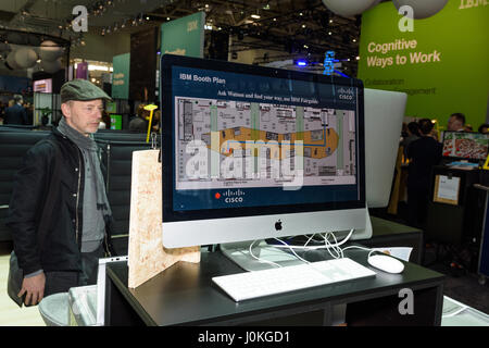 Hannover, Germania - 22 Marzo 2017: l'uomo guarda sullo schermo della IBM piano stand al CeBIT 2017. Il CeBIT è la più grande fiera per l'IT Foto Stock