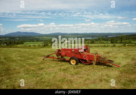 Fienagione rotopressa in campo, Katevale, Quebec, Canada Foto Stock