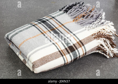 Plaid di lana in gabbia su sfondo grigio. Foto Studio Foto Stock