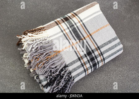 Plaid di lana in gabbia su sfondo grigio. Foto Studio Foto Stock