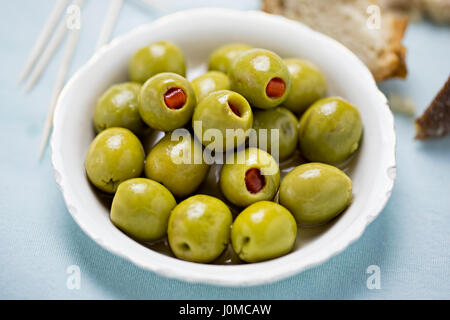 Olive verdi ripiene di peperoni rossi Foto Stock