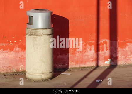 Cestino pattumiera del cestino rifiuti bidoni della spazzatura round di rifiuti al di fuori in strada contro un muro di mattoni con mattoni copia residenziale di spazio Foto Stock