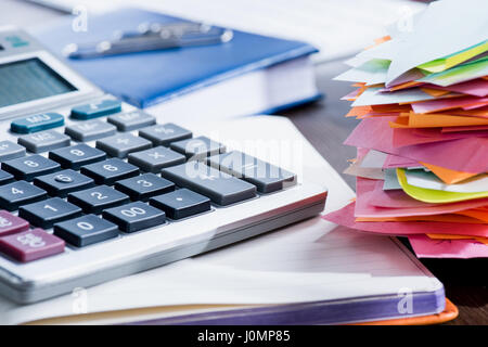 Vista ravvicinata della calcolatrice, notebook e delle forniture di ufficio al lavoro Foto Stock