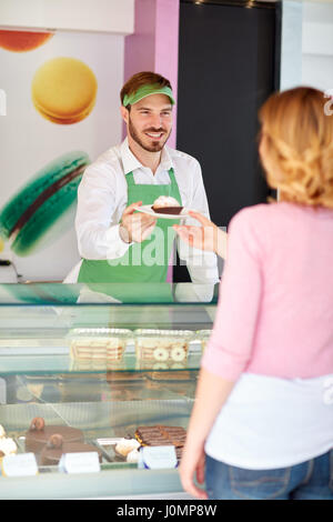 Pasticceria venditore mostra bella tortina su piastra Foto Stock