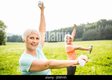 Due delle donne che esercitano con pesi a mano. Foto Stock