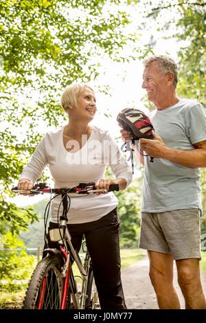 Donna matura in bici, senior uomo con casco. Foto Stock