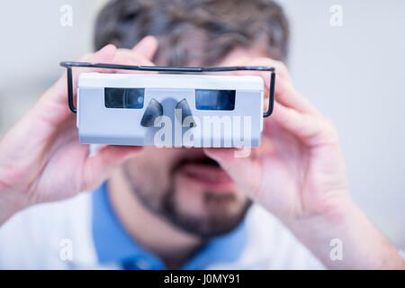 Ritratto di all'ottico optometrista eseguendo la prova dell'occhio con visione screener in all'ottico optometrista del negozio. Foto Stock