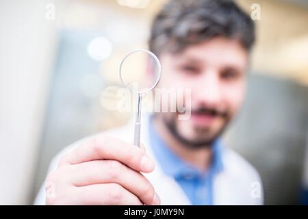 All'ottico optometrista tenendo la lente di ingrandimento. Foto Stock