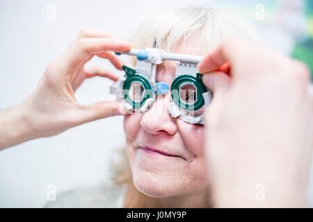 Senior donna con esame visivo da all'ottico optometrista. Foto Stock