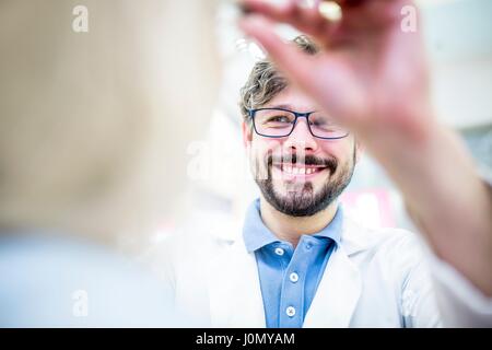 All'ottico optometrista cercando gli occhiali sulla donna in all'ottico optometrista del negozio. Foto Stock