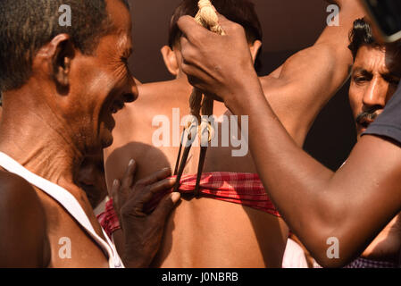 Burdwan,West-Bengal,l'India. Xiv Apr, 2017- devoti ganci trafitto sulla schiena e appeso sulla corda rituale eseguita durante la Charak Puja festival l'ultimo giorno del calendario Bengali in Burdwan. Si tratta di un festival di penitenza dedicato al dio indù Shiva, la folla a guardare questo evento. Foto Stock