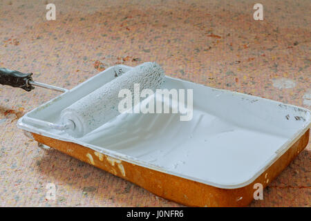 Verniciatura a rullo,impugnatura arancione e nero vassoio di plastica nera sul pavimento di plastica,sfondo,parete di pittura e restauro Foto Stock