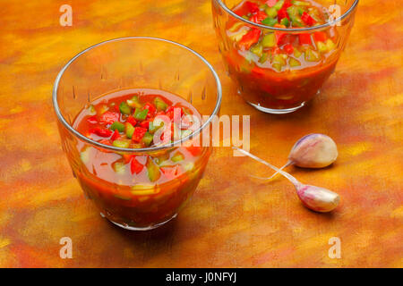 Due ciotole di gazpacho (spagnolo freddo zuppa di pomodoro) con un trito di peperoni rossi e verdi Foto Stock