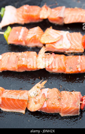 Grigliata di filetti di salmone e gamberetti veloce sano cibo cucinato sulla piastra per la vendita al mercato di strada Bordeaux, Francia Foto Stock