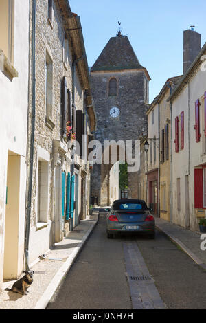 Xiii secolo gateway medievale torre dell orologio, VW Beetle auto e cane nella vecchia bastia città di Duras in Aquitaine, Francia Foto Stock