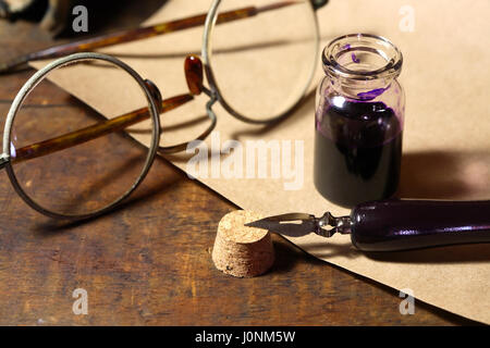 Vintage vita ancora con inkpot e penna vicino a scorrere sul tavolo di legno Foto Stock