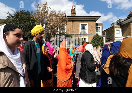 I membri della comunità sikh prendere parte al Nagar Kirtan processione attraverso Gravesend nel Kent, durante il festival di Sikh di Vaisakhi. Foto Stock