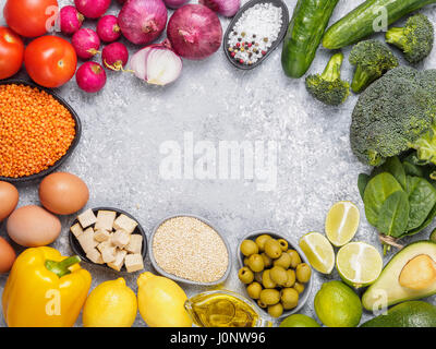 Cibo colorato sfondo. Vegan ingredienti alimentari con copia spazio. Cereali e verdure sul cemento grigio Sfondo. Mangiare sano concetto Foto Stock