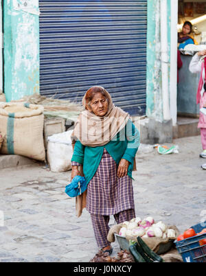 Stropicciata locale indiana vecchia donna indossa tipico abito locale in piedi in una strada di Pragpur heritage village, Kagra distretto, Himachal Pradesh, India Foto Stock