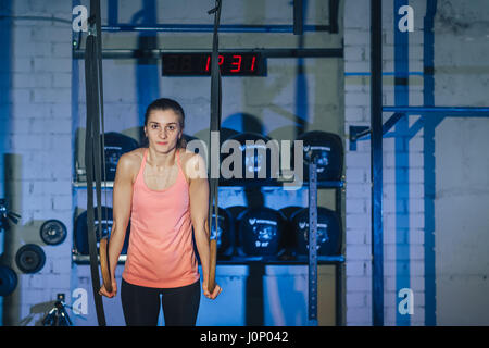 Allenamento sul crossfit anelli. Donna Fitness allenamento sul ricetrasmettitore TRX in palestra. Donna Fitness allenamento sul CrossFit. Donna fitness in palestra. Crossfit donna. Stile Crossfit. Formazione cinghie TRX. Foto Stock