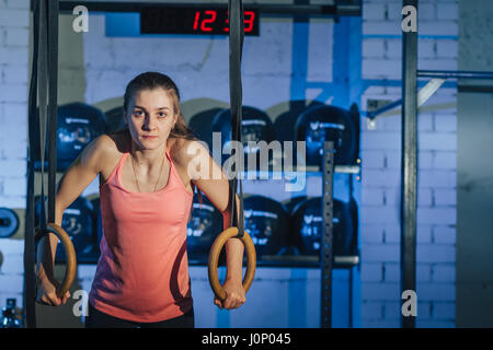 Allenamento sul crossfit anelli. Donna Fitness allenamento sul ricetrasmettitore TRX in palestra. Donna Fitness allenamento sul CrossFit. Donna fitness in palestra. Crossfit donna. Stile Crossfit. Formazione cinghie TRX. Foto Stock