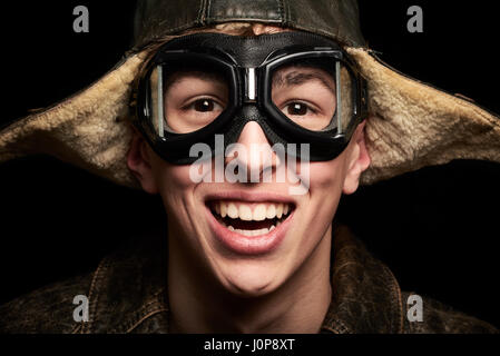 Giovane uomo con cappello e occhiali look vintage su sfondo nero Foto Stock
