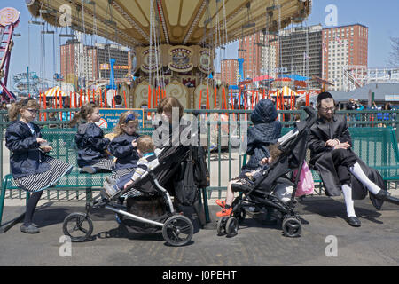 Un religioso della famiglia ebraica per divertirsi durante la Pasqua Ebraica al luna park di Coney Island, Brooklyn, New York City. Foto Stock