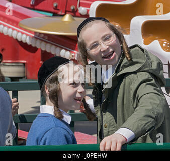 I due religiosi i ragazzi ebrei avendo divertimento durante la Pasqua Ebraica al luna park di Coney Island, Brooklyn, New York City. Foto Stock