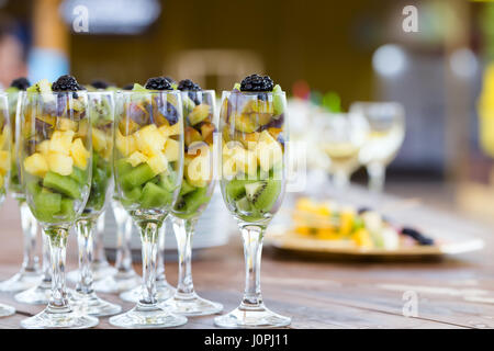Frutta fresca tagli nel bel champagne party bicchieri Foto Stock