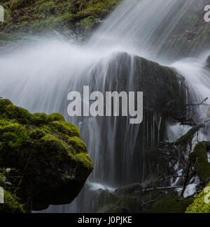 Cascata versando su di una grande grumo di granito. Foto Stock