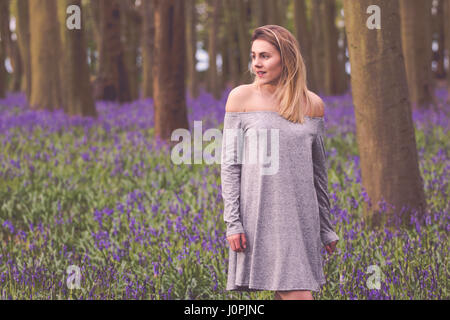 Donna bionda in un Bluebell legno, Wiltshire Foto Stock