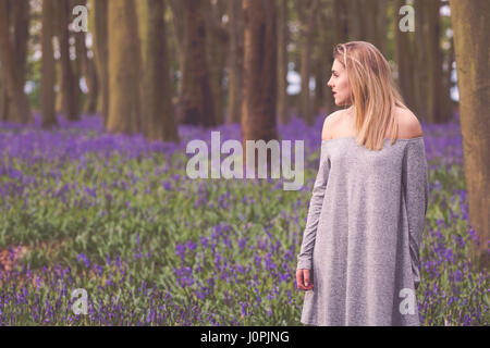 Donna bionda in un Bluebell legno, Wiltshire Foto Stock