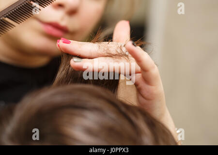 Parrucchiere professionale facendo taglio maschile di capelli. Taglio di capelli con le forbici. Salone di bellezza. Bellezza maschile. Il client è un hipster. Foto Stock