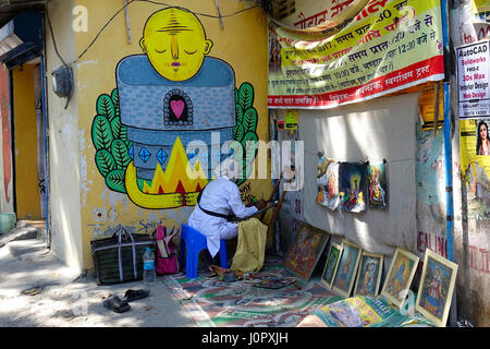 Indian street artista che lavora su strada e di tutte le sue opere visualizzate sul muro, Rishikesh, Uttarakhand, India Foto Stock