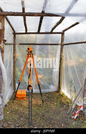 Livello ottico su un cavalletto sotto una tettoia presso il sito del campo di lavoro Foto Stock