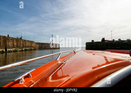 Un power boat lasciando Bridlington Harbour e alla voce del mare. Foto Stock