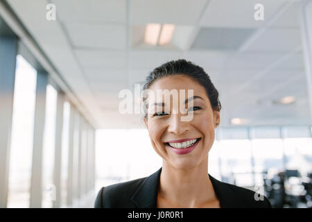 Ritratto di bella coppia imprenditrice in piedi in ufficio e sorridente. Femmina asiatica imprenditore guardando la fotocamera con un grande sorriso sul suo volto. Foto Stock