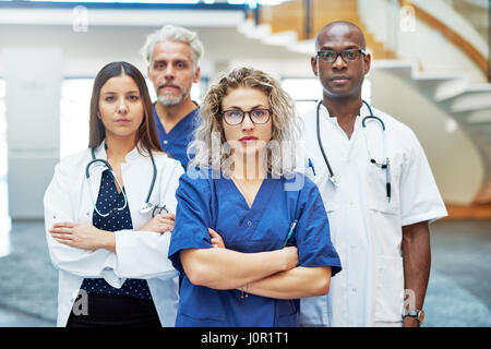 Fiducioso team di medici in piedi all'ospedale guardando nella telecamera Foto Stock