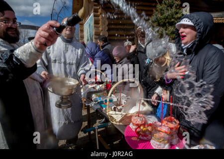 Popolo russo, per celebrare la Pasqua per le strade di Mosca. Un sacerdote ortodosso conduce la cerimonia di consacrazione di Pasqua torte e altri piatti Foto Stock