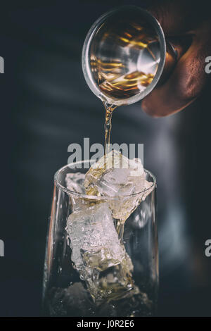 Barista versando alcool in vetro, close up shot Foto Stock