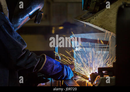 Lavoratore di saldatura parte del settore automobilistico nella fabbrica di automobili Foto Stock