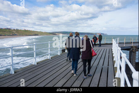 Whitby, North Yorkshire, Inghilterra. Regno Unito. 15th, aprile 2017. Meteo: un brillante ma freddo e ventoso giorno a Whitby sulla North Yorkshire costa come un forte ovest/nord ovest il vento soffia sopra il mare del Nord. Nella foto: un vivace passeggiata sul molo di Whitby in un freddo e ventoso pomeriggio di sabato. Credito: ALAN DAWSON/Alamy Live News Foto Stock