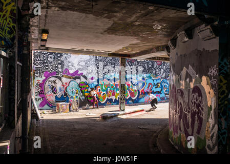 Adolescente skater cavalcare uno skateboard in Leake Street tunnel, Londra, Regno Unito. Leake street noto anche come 'Graffiti 'tunnel' o 'Banksy 'tunnel' è una strada Foto Stock