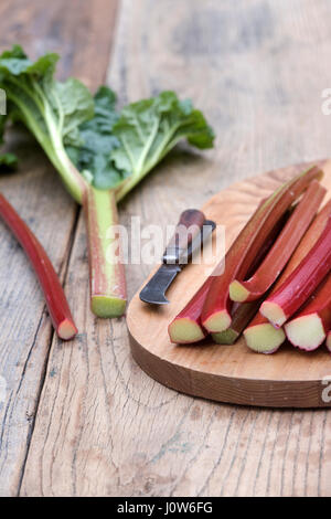 Rheum rhabarbarum. Raccolte di rabarbaro bastoni su una tavola di legno Foto Stock