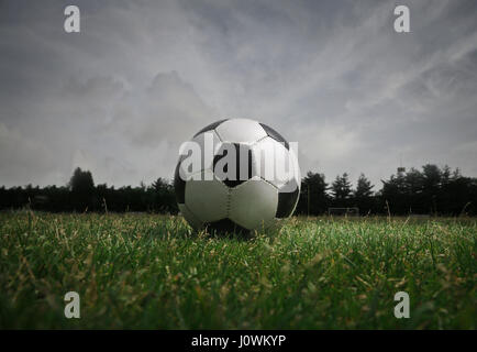 Pallone da calcio sul campo prima di pioggia Foto Stock