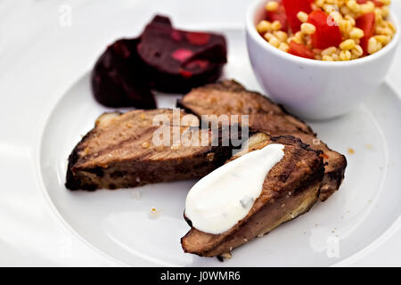 Bistecche di carne di agnello con salsa di aglio, barbabietole e bulgar insalata Foto Stock