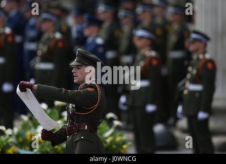 Il capitano Michael Barry delle forze di difesa irlandesi legge una copia della proclamazione durante una cerimonia per celebrare il 101° anniversario della Pasqua 1916 Rising fuori dal GPO, in OConnell Street, Dublino. Foto Stock